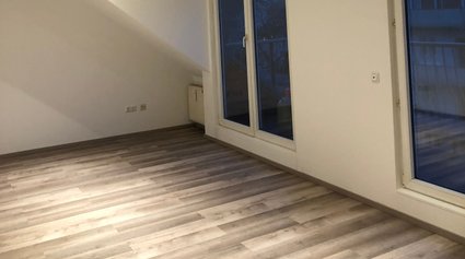 Renoviertes Zimmer in Weiß mit Holzboden