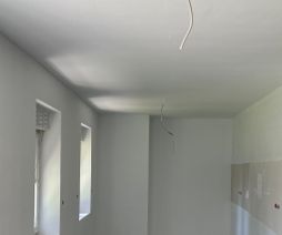 Fertig gestellter Raum mit abgehängter Decke und weißen Wänden nachher