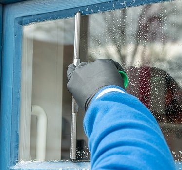 Hand beim Abziehen einer Fensterscheibe Glasreinigung in Düren